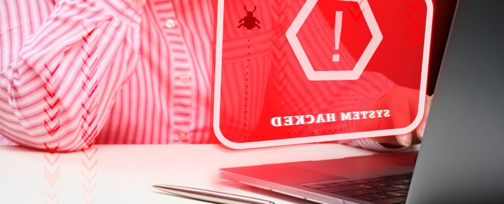 A woman in front of her laptop in distress because her website has been hacked