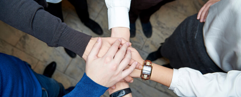 A team joins hands, all of them are talented professionals