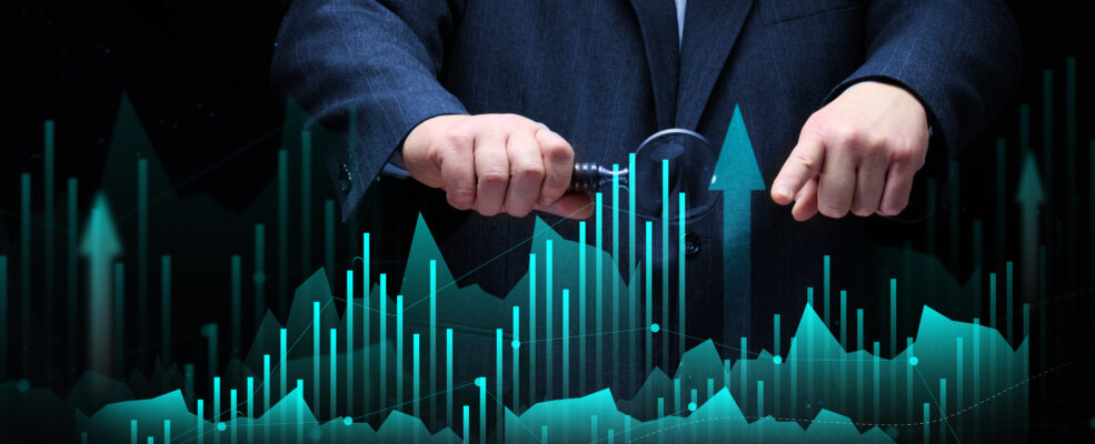 Man in suit scrutinizing statistics with a magnifying glass. This is meant to reflect how your website wins or loses clients