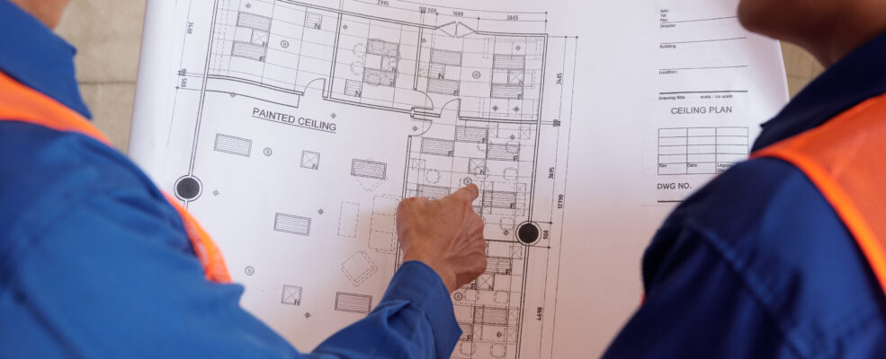 Two engineers discussing blueprints