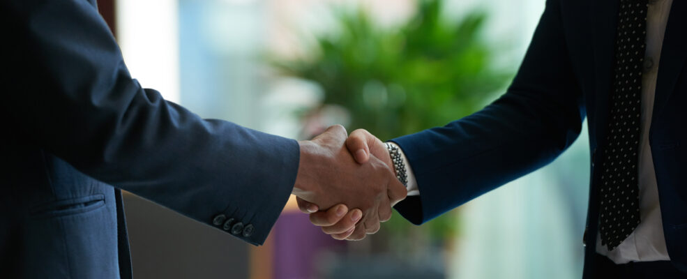 A firm handshake between two business men to illustrate trust